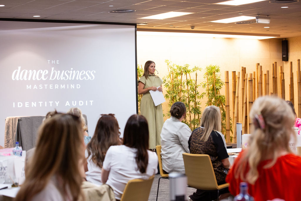 A dance business owner asking a question at a live event
